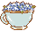 An image of a blue cup with a gold rim. Little blue flowers fill the cup.